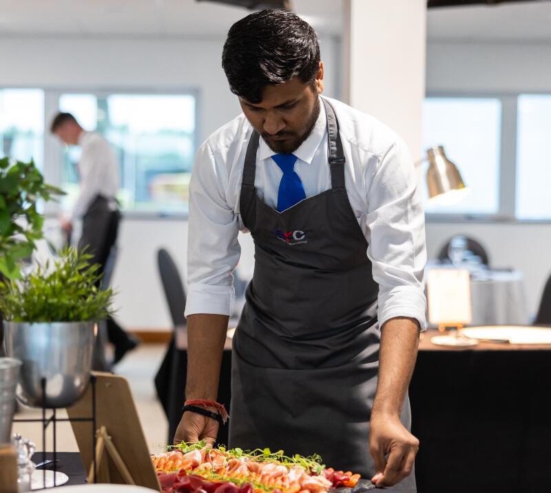 A waiter setting out a buffet